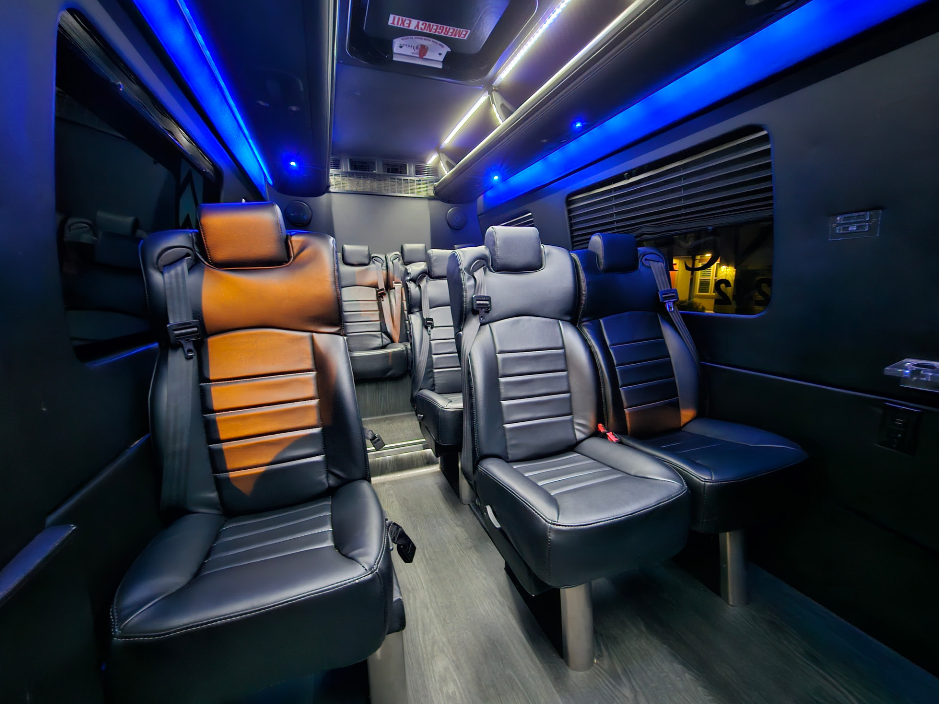 Interior of a 12-passenger Sprinter with leather captain chairs and ambient lighting