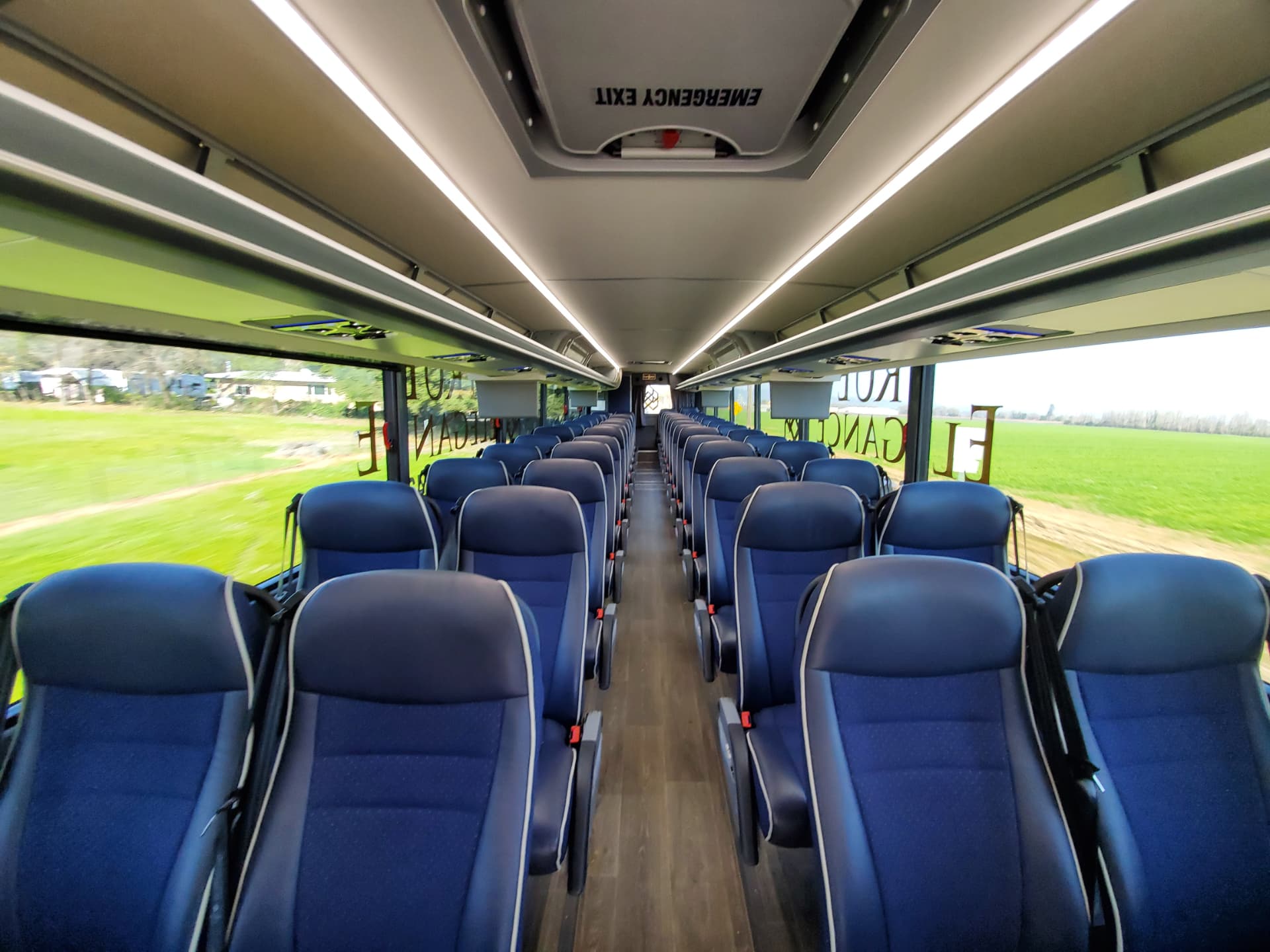 Interior of a 56-passenger coach with navy reclining seats and center aisle